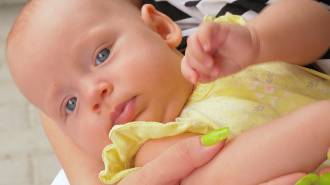 3개월 된 아기 소녀가 엄마의 손에 누워있어요