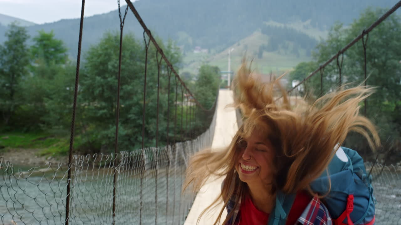 turista saltando puente de montaña en una gira de vacaciones. hermoso excursionista bailando al aire libre