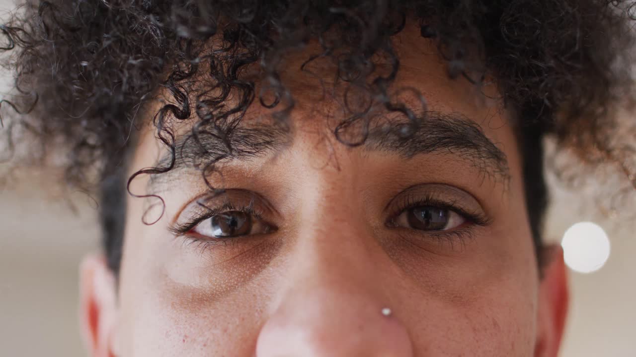 retrato de un feliz hombre biracial mirando a la cámara en un estudio de baile, cámara lenta