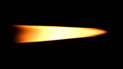 one candle burning brightly against black background