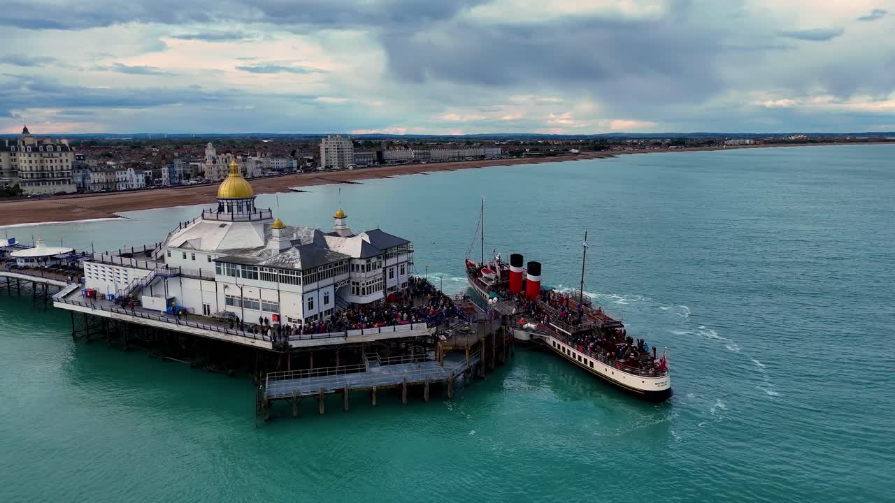 Aerial footage captures Waverley, the world's last sea-going paddle steamer, gracefully docked at the pier