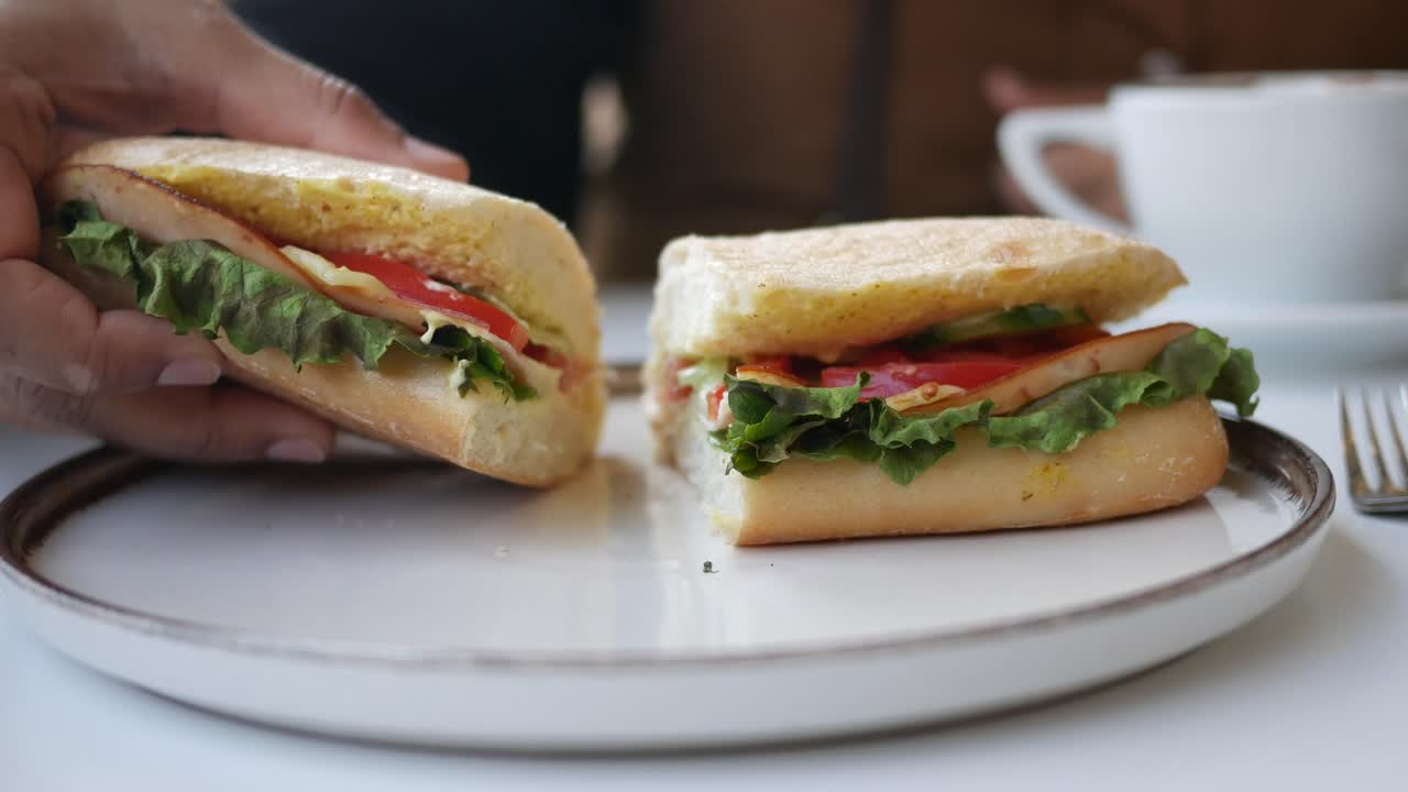 Person eating a delicious sandwich with coffee