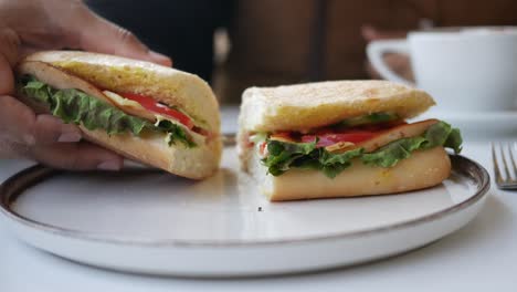 person eating a delicious sandwich with coffee