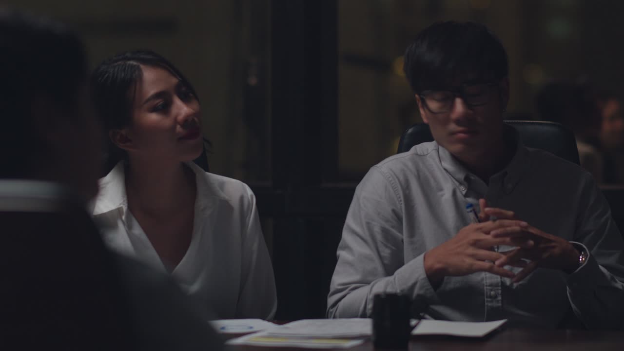 Millennial Asia businessmen and businesswomen meeting brainstorming ideas about new paperwork project colleagues working together planning success strategy enjoy teamwork in night office.