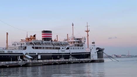 Oldtimer-Ozeandampfer-Im-Hafen-Während-Der-Dämmerung-Angedockt,-Ruhiges-Wasser-Mit-Pastellfarbenem-Himmel