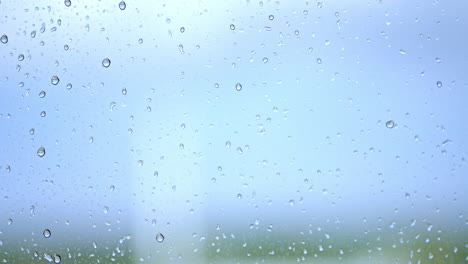 Rain droplets on window with blurred background.