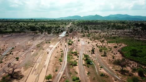 rider riding motorbikes on dirt road through kenya in east africa