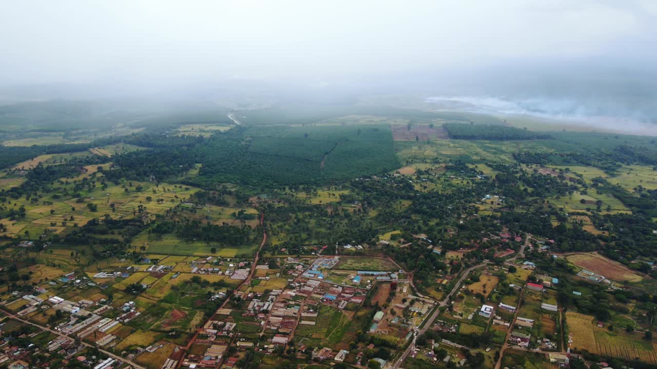vista aérea de un pueblo rural en áfrica, lluvia entrando - reversa, disparo de drones