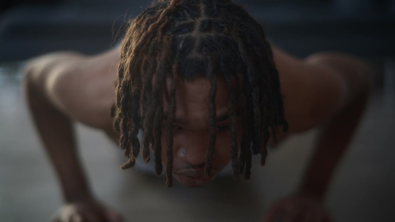 A young adult male doing pushups in the living room at home