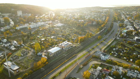 Aerial-backwards-shot-of-bright-sunbeams-shining-over-colorful-City-of-Gdynia-in-Poland-during-sunny-autumn-day