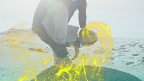 Golden-digital-wave-against-african-american-fit-man-tying-his-shoe-laces-at-the-beach