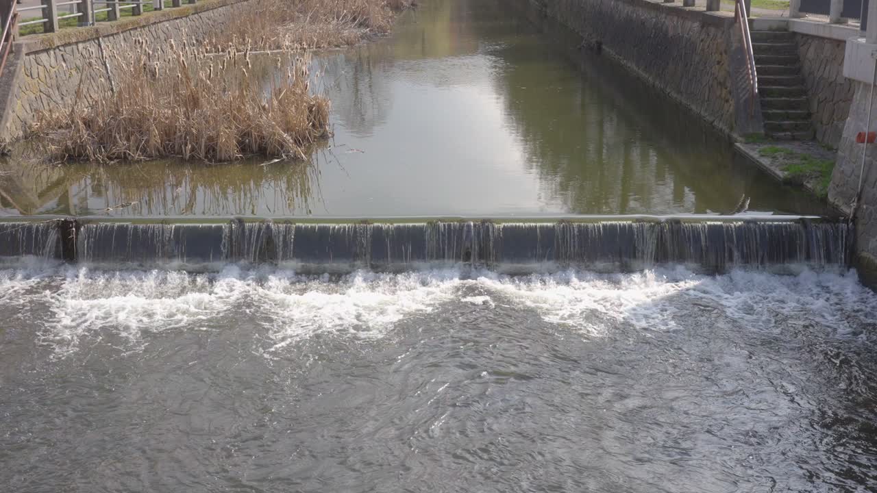 A river with a weir through which water flows
