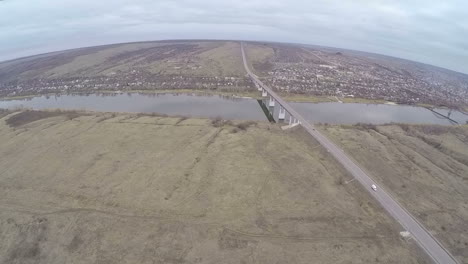 Aerial-shot-of-cars-driving-on-bridge-over-the-river