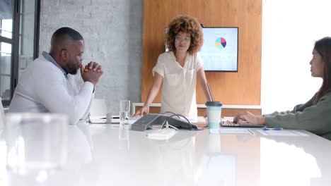 Focused-diverse-male-and-female-colleagues-at-office-meeting,-using-laptop-and-monitor,-slow-motion