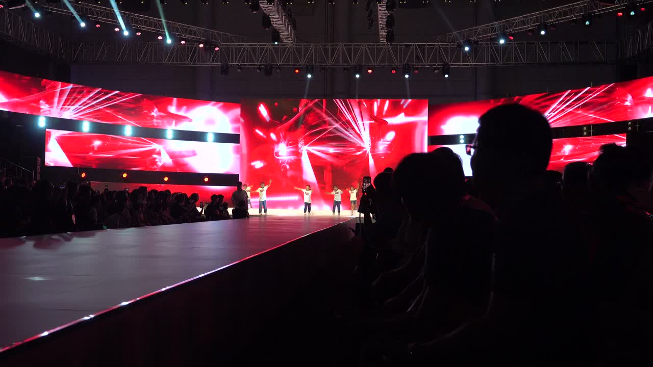 Young Dancers Perform on Stage with Vibrant Red LED Background
