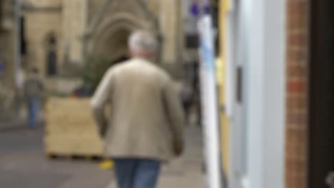 defocused shot of elderly man walking down quiet street in oxford