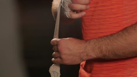 male boxer wrapping hands before fighting in slow motion. close-up of young athlete getting ready for fight. man preparing. sport concept in 4k, uhd