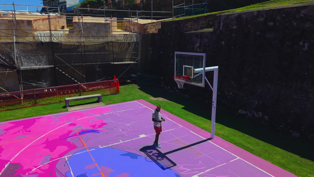 Volo immersivo e ad alta velocità con drone FPV (First-Person View) che si tuffa nei vivaci vicoli, nei murales colorati di street art e nelle scogliere sul mare del quartiere La Perla a San Juan.