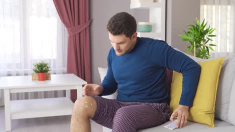 Injured-man-applying-cream-to-his-leg.