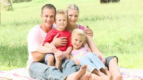 Familia-Sentada-En-Un-Parque