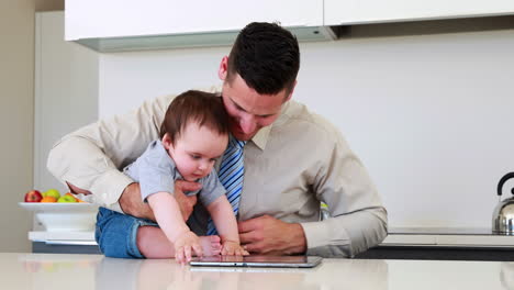 Vater-Hält-Sein-Baby-Vor-Der-Arbeit-Und-Verwendet-Tablet-PC