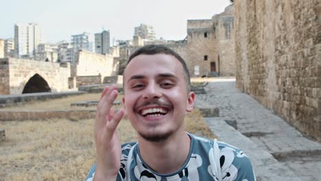 funny man at the citadel of raymond de saint-gilles in tripoli, lebanon laughs as he talks in front of camera