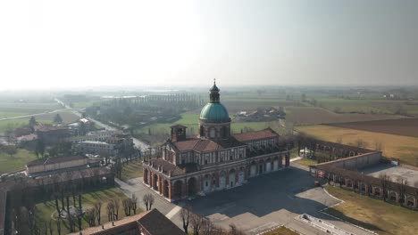 Aerial-footage-of-Lombardy's-Santuario-di-Caravaggio-captured-by-drone-in-soft-sunlight,-showcasing-the-architectural-and-natural-beauty-of-the-region