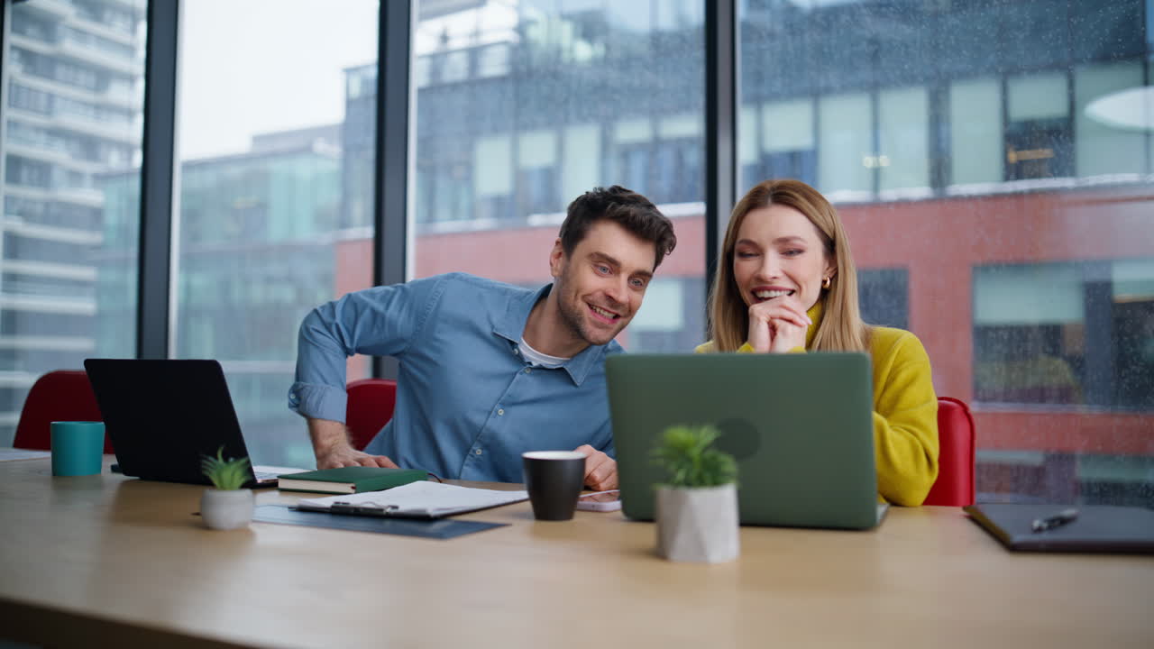 Smiling colleagues talking workplace closeup. Man looking on woman laptop