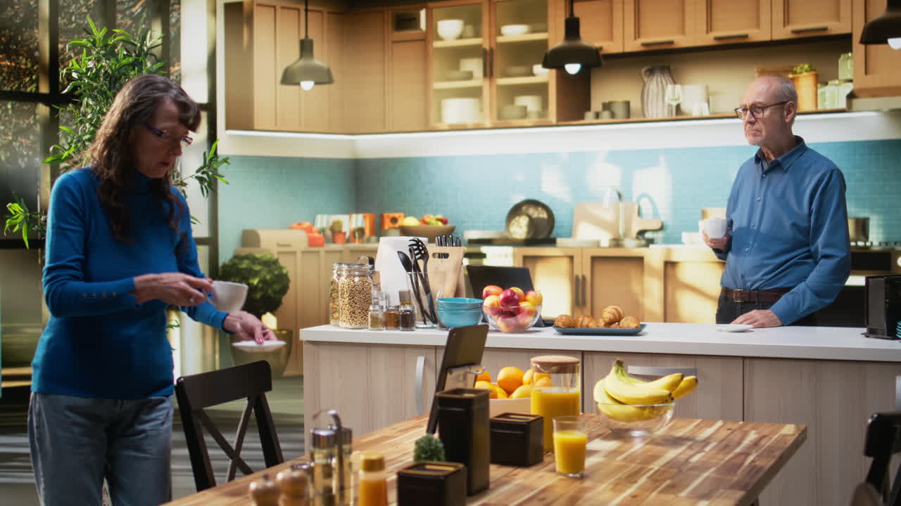 Elderly pensioners enjoy calm household life at the kitchen counter