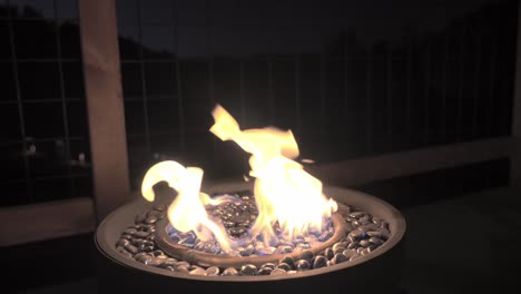 modern gas-powered fire pit, featuring decorative glass marbles that shimmer in the glow of the flames