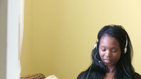 Merry-young-woman-working-at-a-laptop-with-headset-on