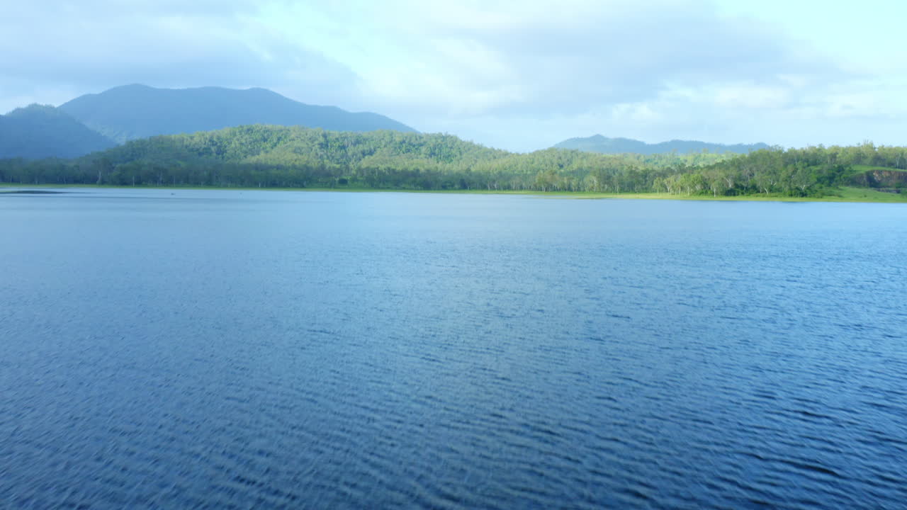푸른 나무와 산을 향해 푸른 물 댐을 가로지르는 공중 드론 패닝, 4k
