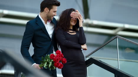 girl waiting for guy outdoors. couple hugging with red roses at street