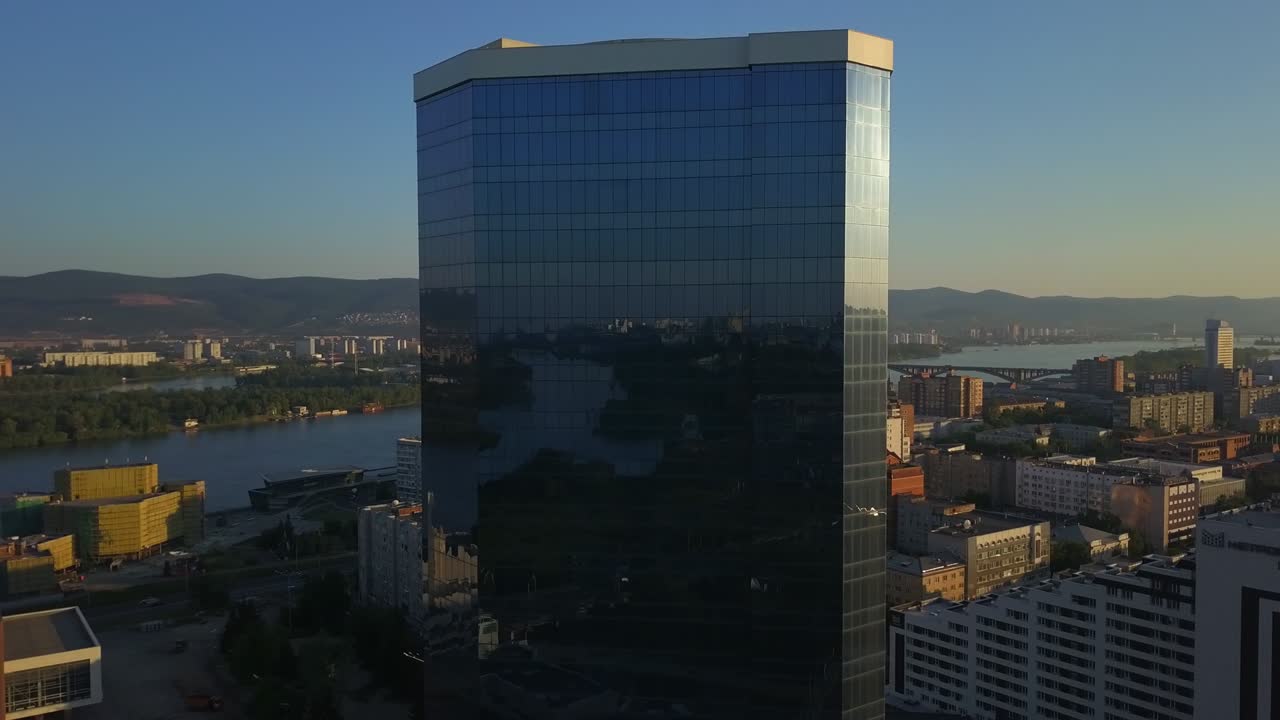 vista de un edificio de oficinas moderno que refleja el paisaje de la ciudad en imágenes de drones de krasnoyarsk