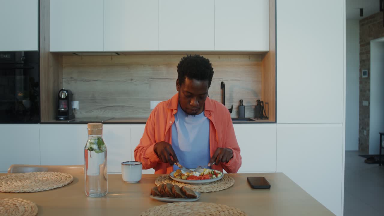 hombre comiendo una comida saludable en una cocina moderna