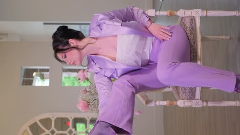 a woman in a purple suit exudes confidence grace and elegance a poised woman in a purple suit sits elegantly exuding confidence with a flower in hand she embodies serene beauty and sophistication