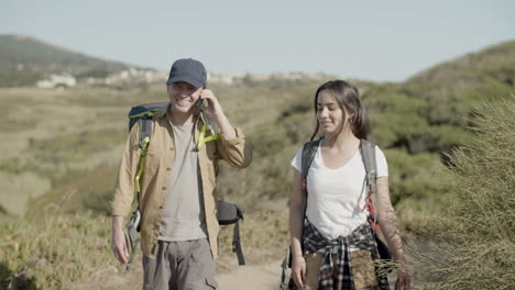 front view of father and daughter with backpacks hiking together