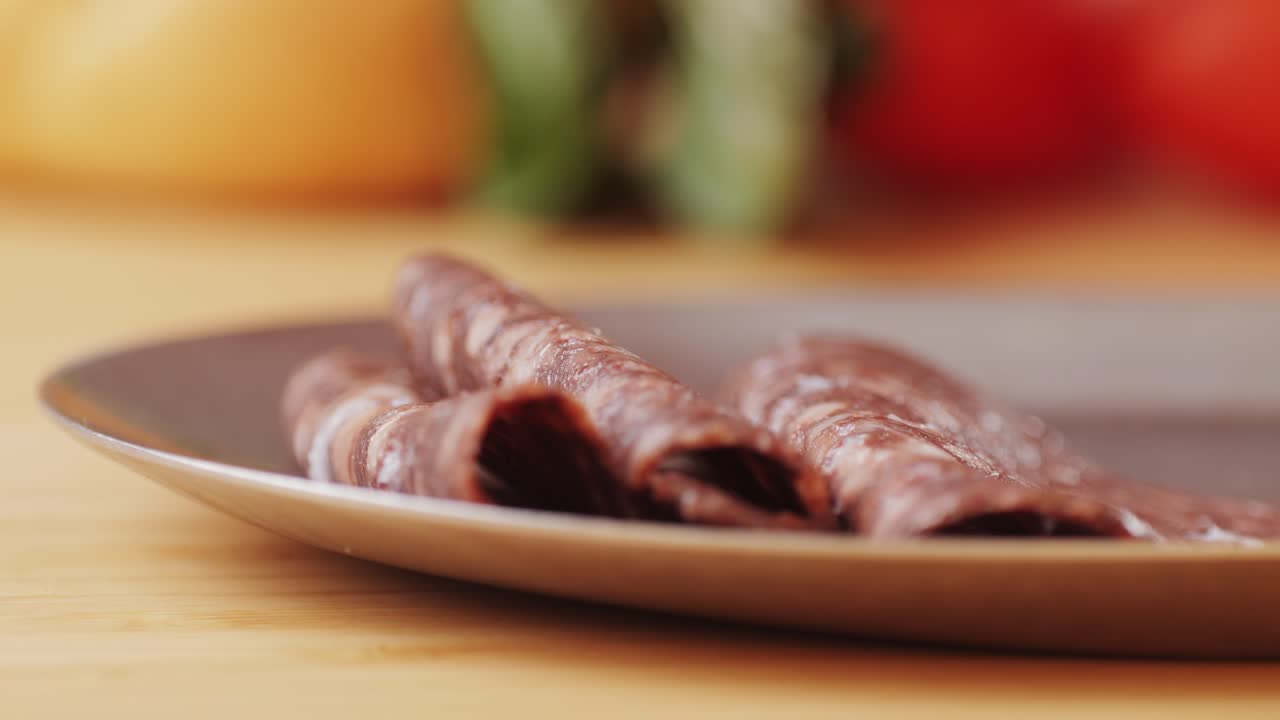 Salame di toro nero, salame di lingua di maiale stagionato su sfondo nero, specialità gastronomica tradizionale spagnola, primo piano