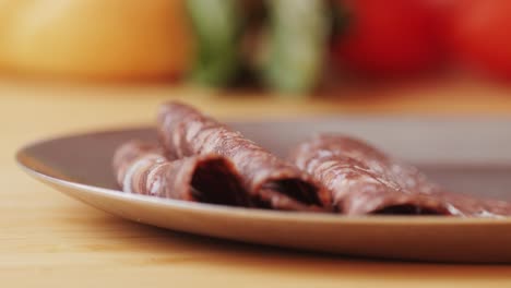 black bull sausage ham, tongue pork dry-cured sausage on a black background, traditional spanish delicatessen food, close up.