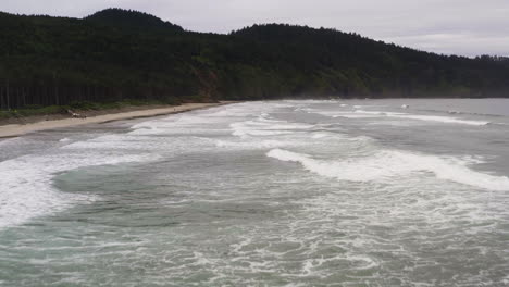 Aerial-dolly-above-crashing-waves-spreading-across-waters-of-Cape-Lookout,-Oregon-Coast