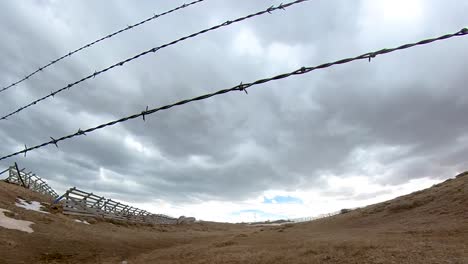 stormachtige luchten donderen langs een oud westelijk landschap met prikkeldraad op de voorgrond