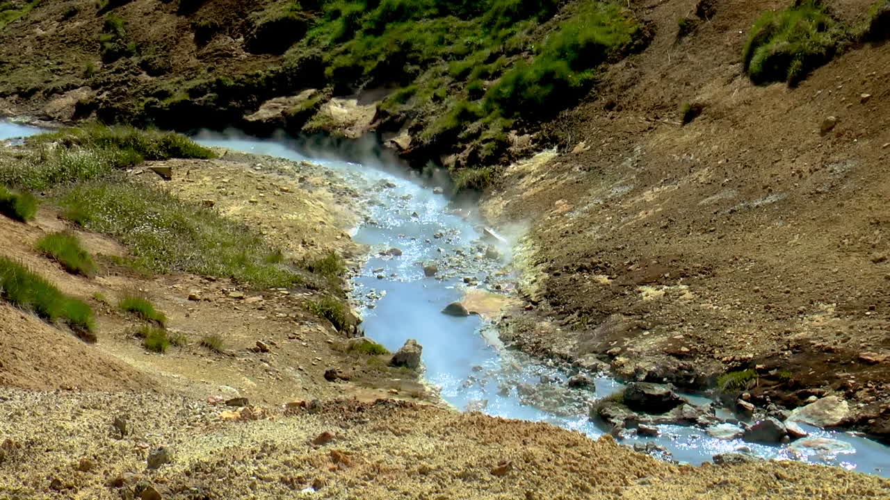 imágenes en cámara lenta de un río caliente y hirviendo con humo de manantiales termales en el área geotérmica de seltun en islandia