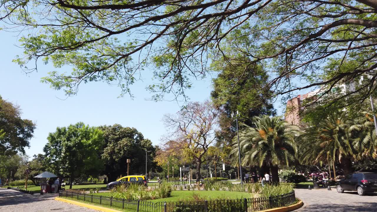 A Taxi Vehicle turns around in intersection at Las Heras Park, Public green urban plaza in Buenos Aires city at Spring daylight