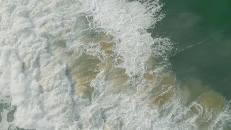 tomas aéreas de arriba hacia abajo de 4k de olas rompiendo en las playas de varkala en la mañana