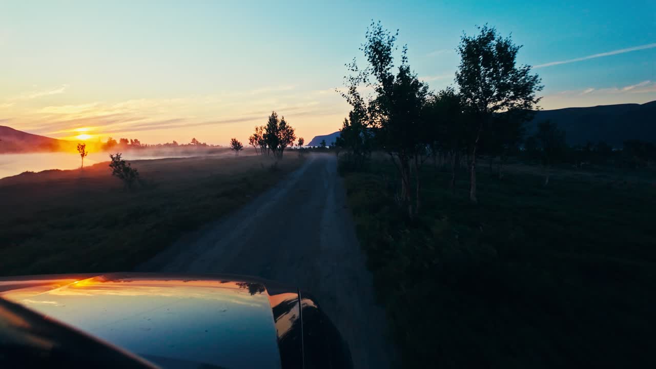 Guidando lungo una tranquilla strada di campagna al tramonto a Sandland, comune di Loppa, Finnmark, Norvegia - Ripresa POV