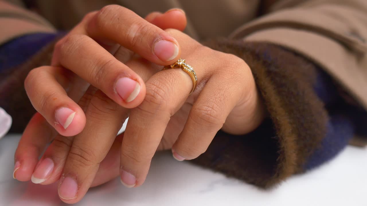 Close up of a Woman's Hands with a Gold Ring