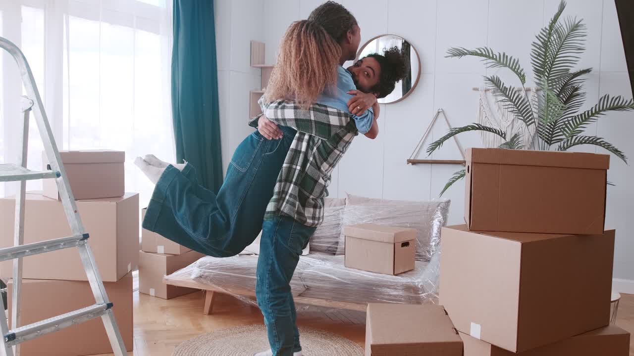 Young overjoyed man lift woman and spin around hugging after buying property