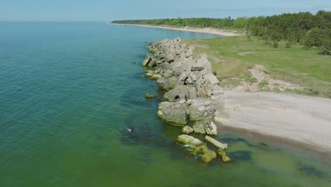 Wunderschöne-Luftaufnahme-Der-Ruinen-Der-Betonküstenbefestigung-Von-Karosta,-Ruhige-Ostsee,-Sonniger-Sommertag,-Breite-Aufsteigende-Drohnenaufnahme-In-Vorwärtsbewegung,-Kamera-Nach-Unten-Geneigt