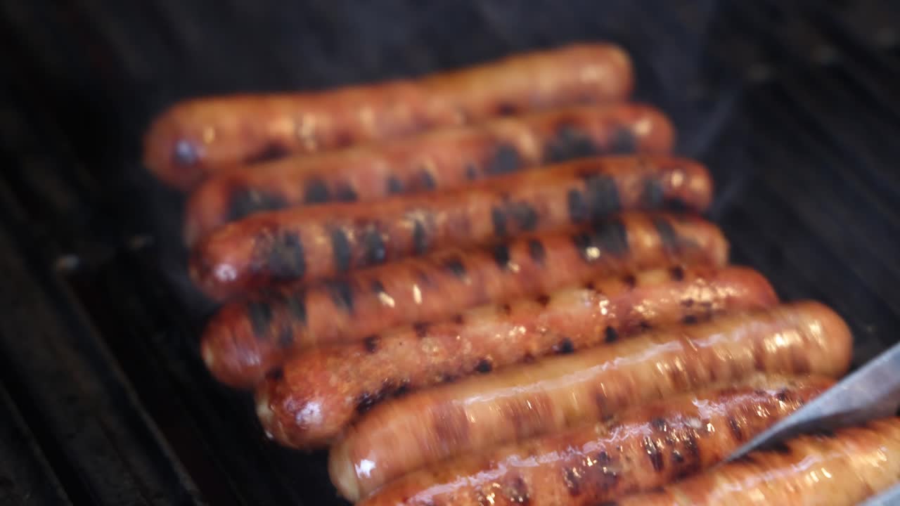 Sizzling sausages cooking evenly on a grill