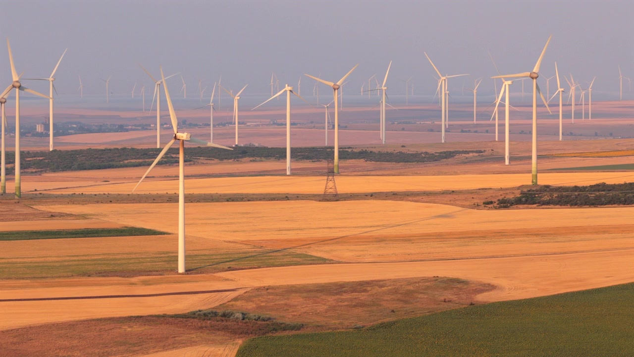 Vindturbiner som står på et stort jordbruksfelt og omdanner vind til ren energi. Romania
